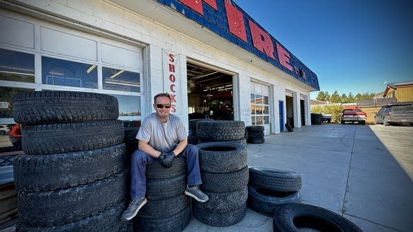 Kirk Griggs sits on tires outside his business, The Tire Store, in Pinedale, Wyoming. It's been in his family for 39 years. 