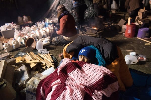 Ajay Kyle, 6, huddles under blankets near her dad.