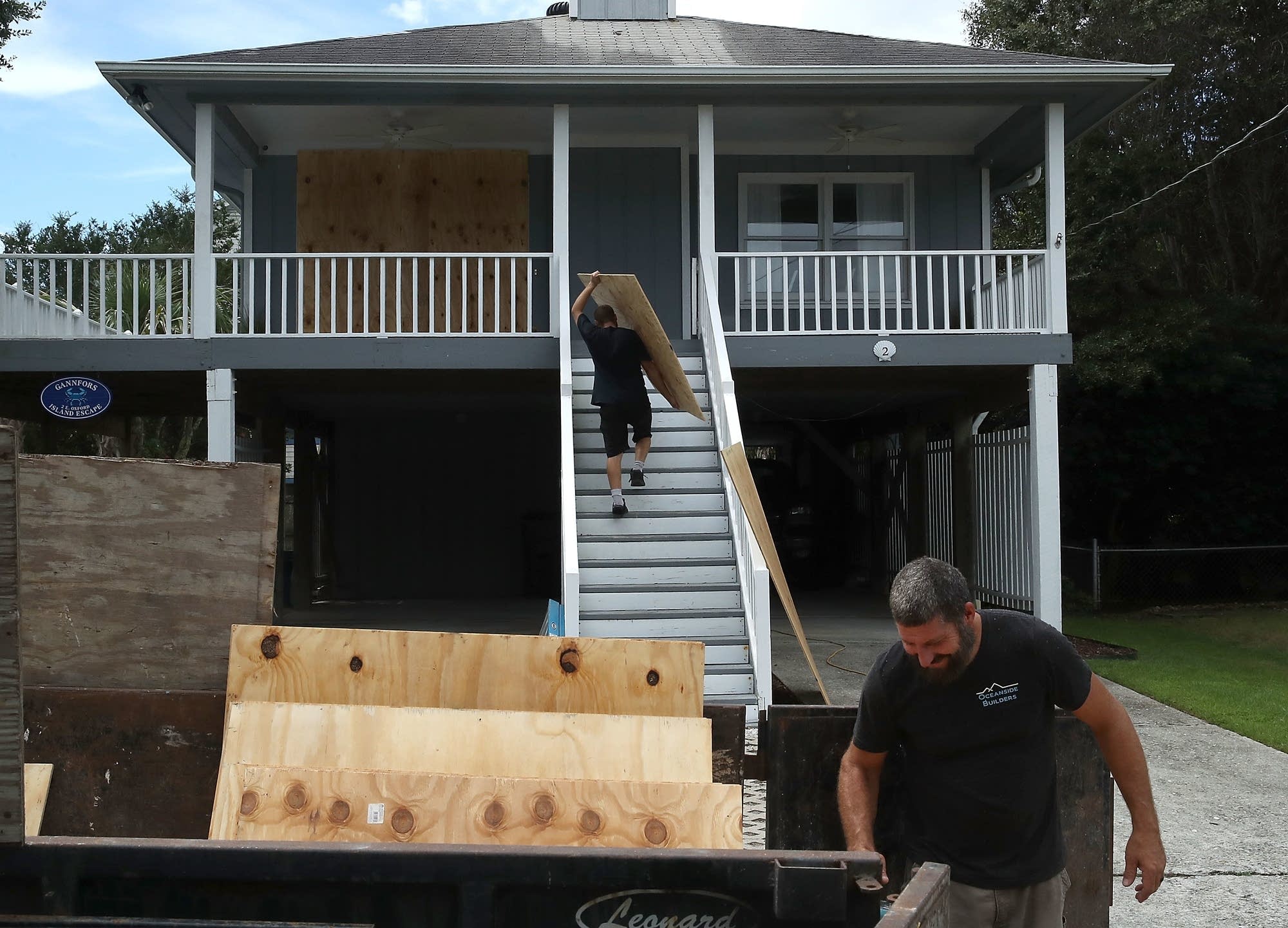 Clint McBride cuts plywood to be put over a home's window.