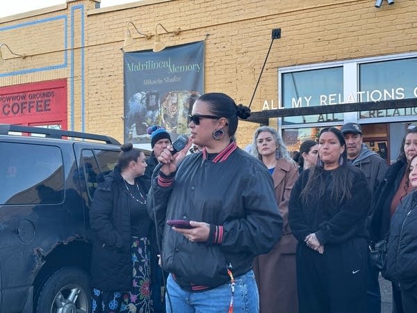 Person in sunglasses speaking to a crowd