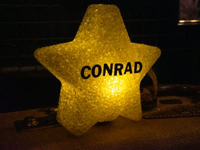 A lit up yellow star with "Conrad" on it.