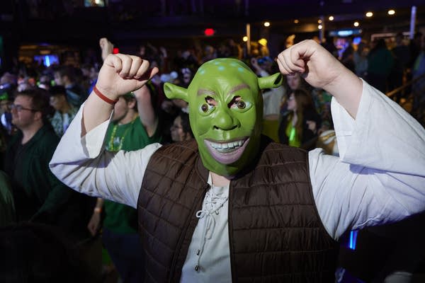 A person wears a shrek head