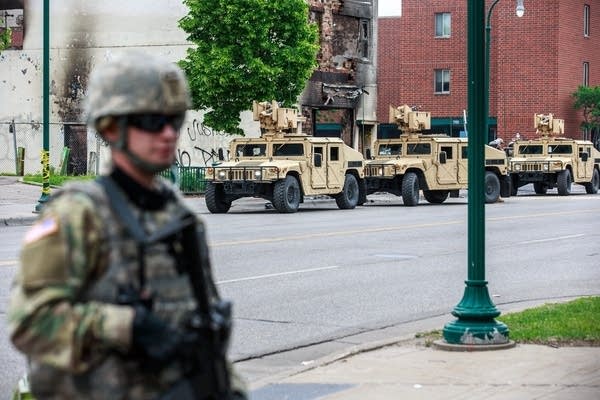 Minnesota National Guard soldiers patrol a street. 