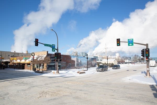 White exhaust floats above a snow covered street.