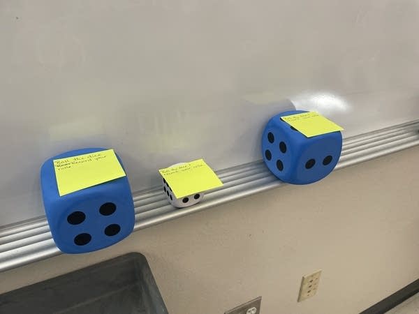 Dice are some of the classroom tools for a personal finance lesson in Mustang, Oklahoma