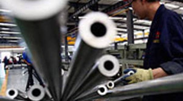 Chinese worker moves aluminum pipes at the Qinghai Guoxin Aluminium Industry Incorporated Company workshop in Xining of Qinghai Province, China.