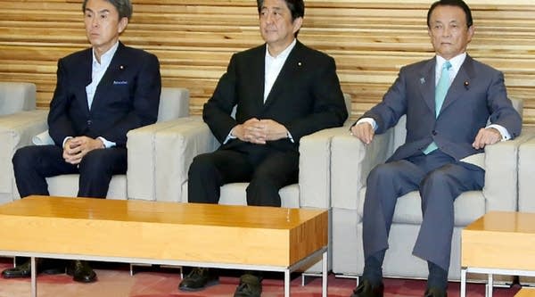 Japanese Prime Minister Shinzo Abe (center) sits with Finance Minister Taro Aso (right) and Economic Revitalisation Minister Nobuteru Ishihara (left) as they pose for photographers prior to a cabinet meeting at Abe's official residence in Tokyo on Tuesday.
 