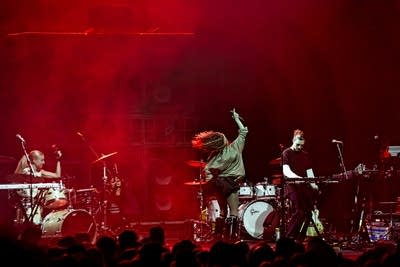 A band performing onstage in a large music venue