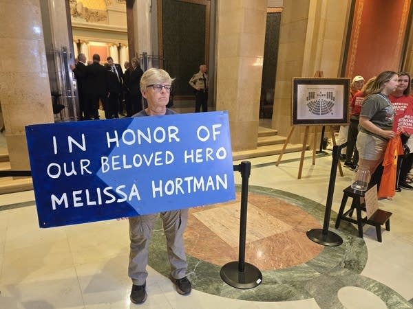A person holds a sign