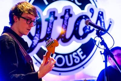 Two musicians performing onstage in a music venue