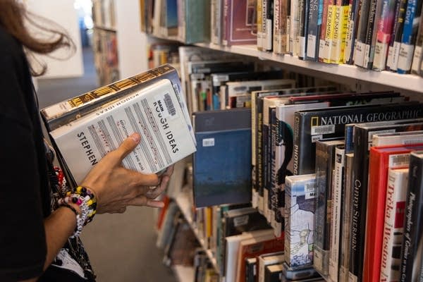 A person holds books at a library.