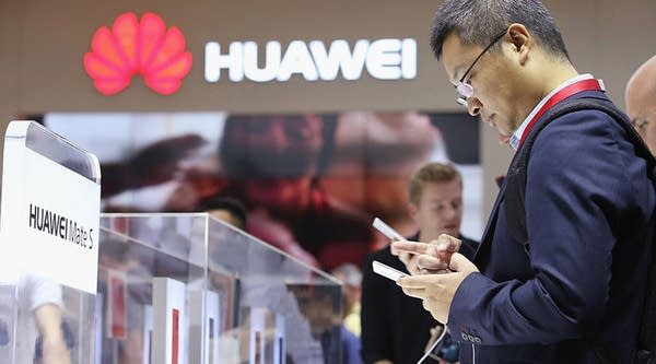 Visitors try out Huawei smartphones at the 2015 IFA consumer electronics and appliances trade fair in Berlin.