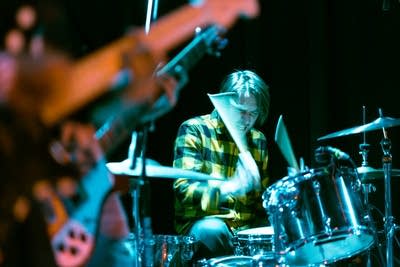 A musician plays drums onstage