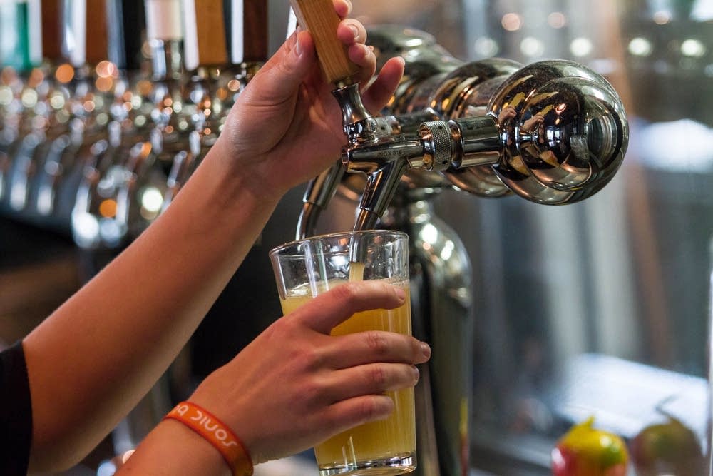 A bartender pours a beer.
