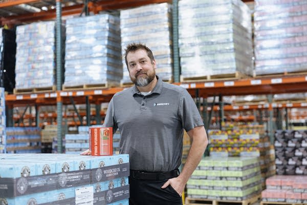 A man poses for a photo in a warehouse