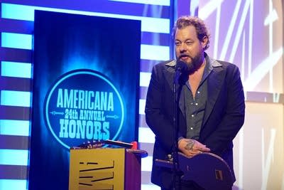 A man speaks onstage after winning an award
