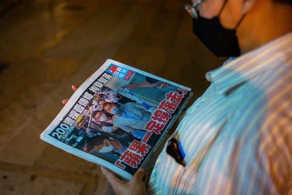A man buys Next Digital's newspaper, Apple Daily, after the company's founder was arrested under a new national security law.