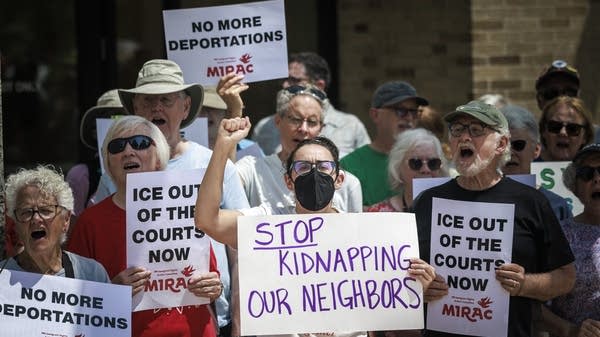 Protesters chant and hold signs calling for due process and an end to deportations during a rally in Minneapolis. 