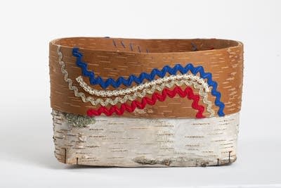 A woven birch basket with wavy red, white and blue accents.