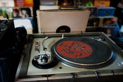 A record turntable sits ready for use in a record store