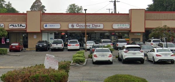 Photo of outdoor strip mall with "Golden Deli" in center