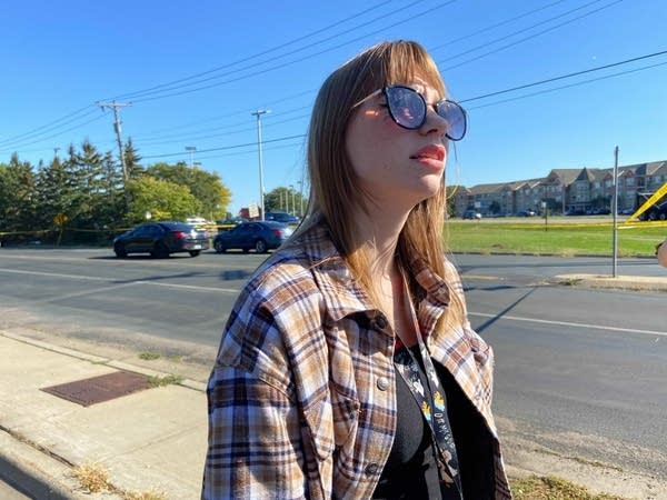 a woman stands next to a street