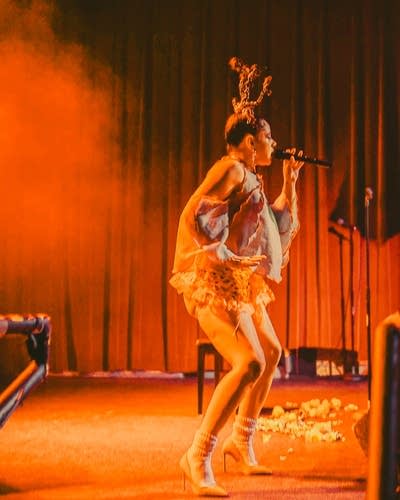 XINA sings into a microphone onstage at Fine Line.