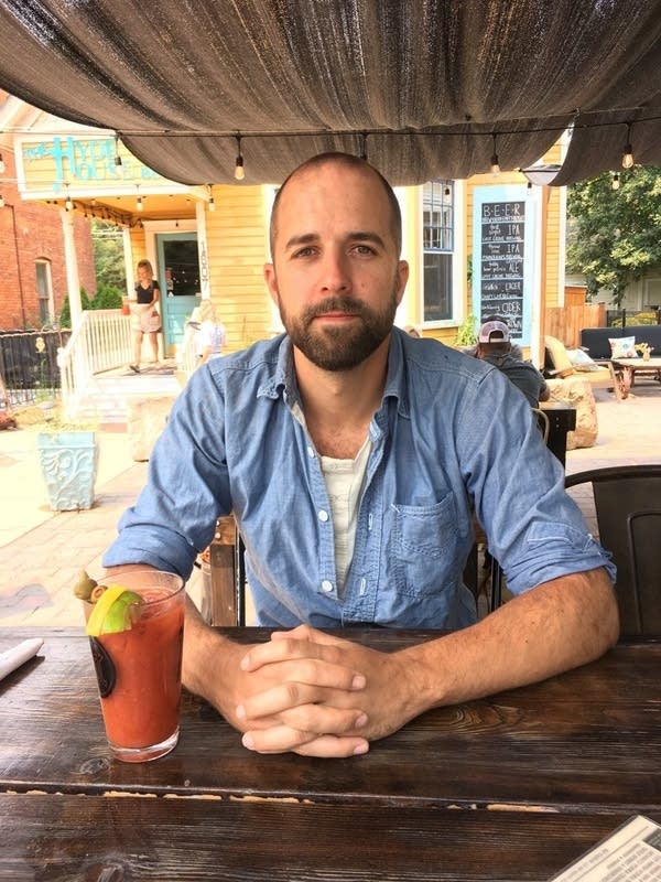 A man seated at an outdoor table at a restaurant