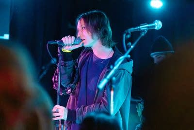 A man singing into a microphone onstage