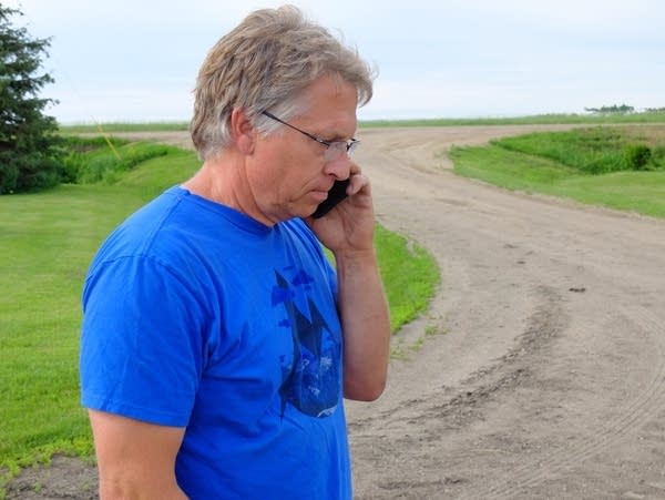 Mark Askegaard makes a phone call at his farm near Comstock, Minn.