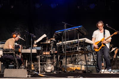 Passion Pit performing on an outdoor stage.