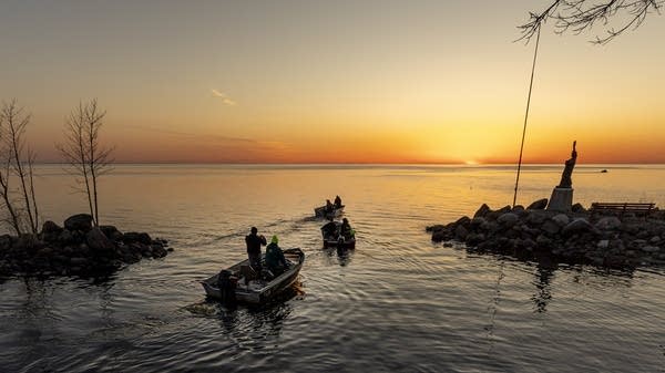 Fishing boats on a lake at sunset.