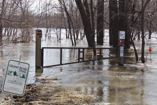 Floodwaters overtake a trail on the edge of Henderson, Minn.