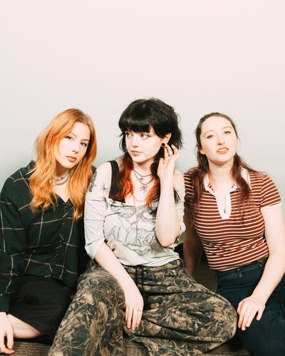 Three musicians sit together for a portrait