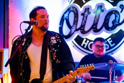 Two musicians performing onstage in a music venue