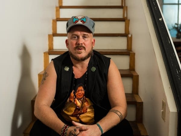 David Huckfelt sits on a white staircase.