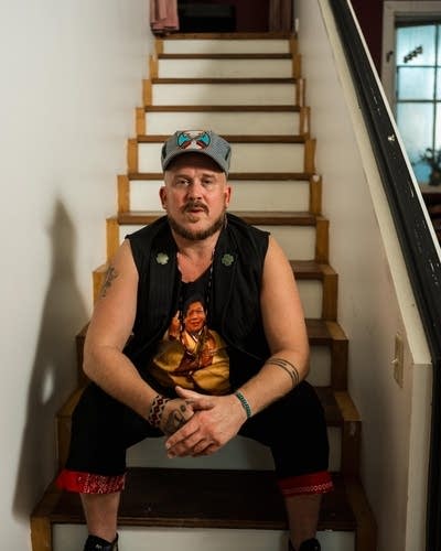 David Huckfelt sits on a white staircase.