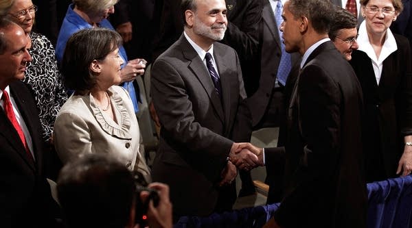 U.S. President Barack Obama (3rd R) shakes hands with Federal Reserve Bank Chairman Ben Bernanke (C) as FDIC Chair Sheila Bair (2nd L) looks on.
