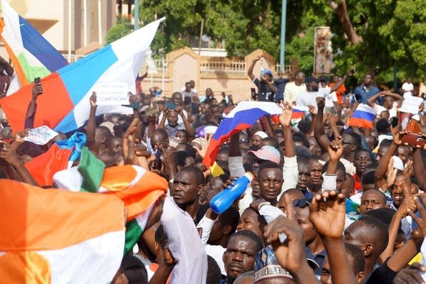 Coup supporters unfurl a Russian flag as they take to the streets 