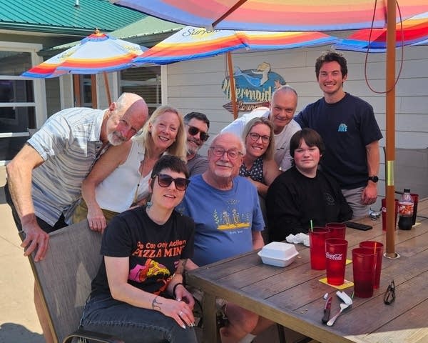 A group photo at a restaurant outdoor table.