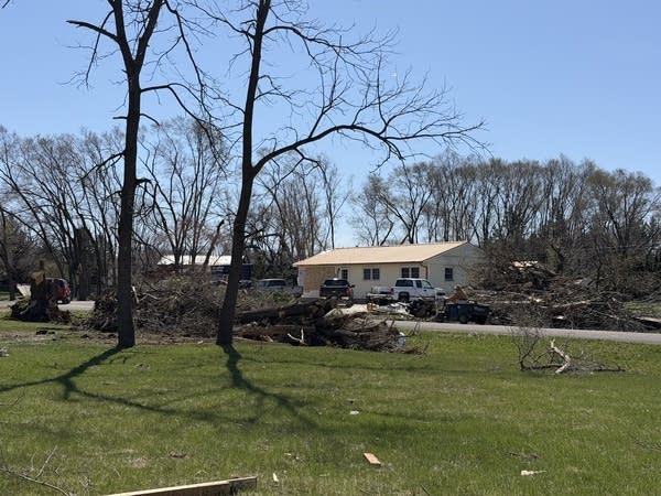 Piles of debris are stacked next to a house.
