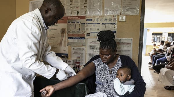 Above, a hospital worker prepares lab work for a mother at a hospital in Ksumu, Kenya, that was once supported by USAID. 