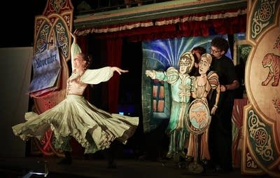 A dancer and puppets performing onstage