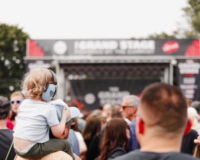 Young child wearing headphones in the crowd