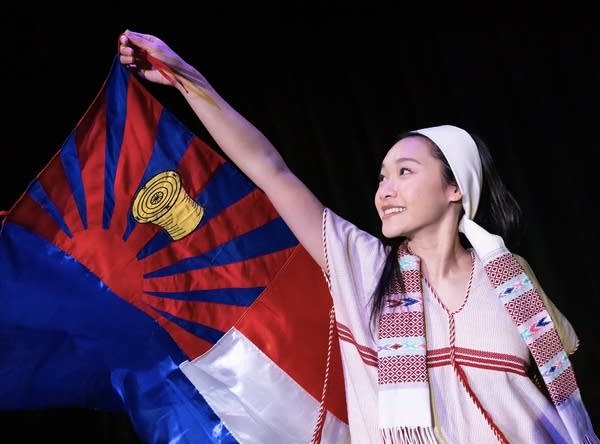 A woman stands with a flag