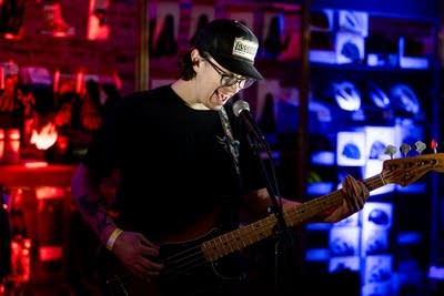 A musician plays bass onstage in a nontraditional music venue