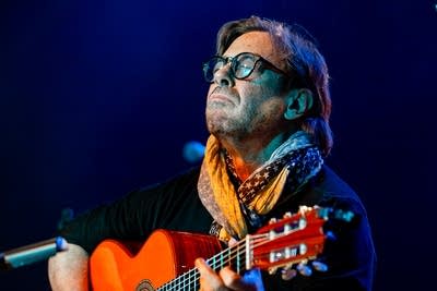 Al Di Meola performing with a guitar on stage