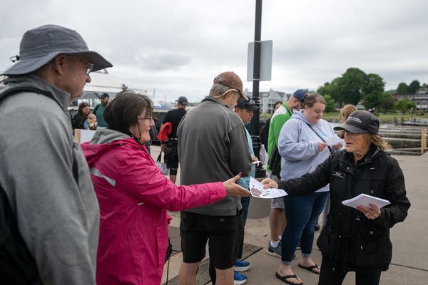 A person passes out maps