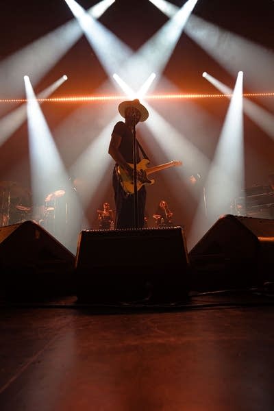 A musician plays guitar in a large music venue