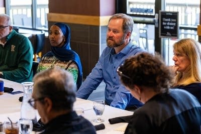 A group talks around a large table in a restaurant.